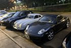 Porsche entre un suv porsche et un cayman... et une porsche à côté d'une voiture intelligente. Les Porsche sont vraiment petites!